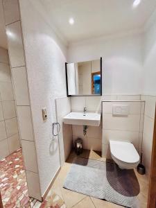 uma casa de banho branca com um lavatório e um WC em "Apart Edi" inkl SILVRETTA PREMIUM SUMMERCARD em See