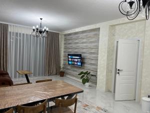 uma sala de jantar com uma mesa e uma televisão na parede em Favorite House em Qusar
