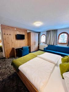 um quarto com uma cama grande e um sofá azul em "Apart Edi" inkl SILVRETTA PREMIUM SUMMERCARD em See