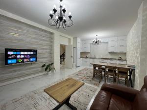 a living room with a table and a kitchen at Favorite House in Qusar