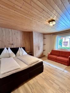 um quarto com uma cama e um sofá vermelho em "Apart Edi" inkl SILVRETTA PREMIUM SUMMERCARD em See