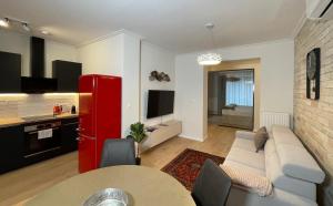 ein Wohnzimmer mit einem Sofa und einem roten Kühlschrank in der Unterkunft Cityluxandloft Bestern 2 in Szeged