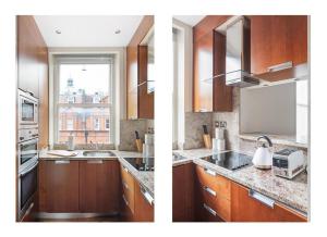 een keuken met houten kasten, een wastafel en een raam bij The Sophisticated Apartment in Knightsbridge in Londen