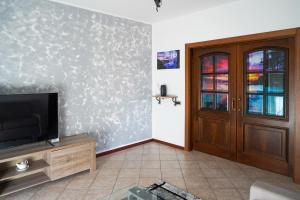 sala de estar con TV y puerta en A Home away From Home By Alex Appartamento Malpensa Prestige Residence en Busto Arsizio
