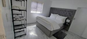 1 dormitorio con 1 cama grande con sábanas y almohadas blancas en Walvis Bay Staycation, en Walvis Bay