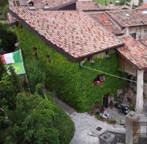 a building covered in ivy with a flag on it at Il Fienile in Tremosine Sul Garda