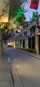 una calle vacía con banderas y edificios coloridos en Hostal 1811, en Cartagena de Indias