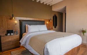 a bedroom with a large bed with white sheets at Suite de Lujo con Terraza Panorámica in San Miguel de Allende