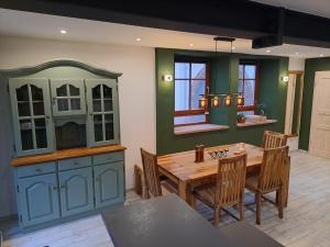 a kitchen with a wooden table and a dining room at Gästehaus Merlin in Bad Bergzabern