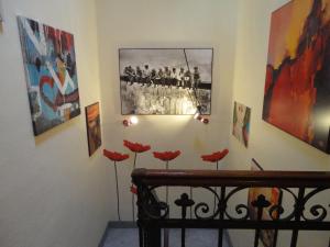 a room with paintings and red flowers on the wall at Hostel Pisa Tower in Pisa