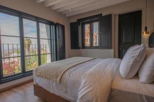1 dormitorio con cama y ventanas con vistas en Suite de Lujo con Terraza Panorámica, en San Miguel de Allende