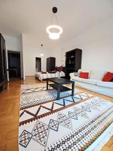 sala de estar con sofá y mesa sobre una alfombra en Hero's Square Apartment en Budapest