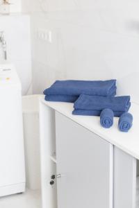 a white bathroom with blue towels on a counter at Appartment mit Parkplatz in Würzburg