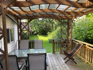 a pergola on a deck with a table and chairs at LuxuryCottage-2KingBeds PrivateYard Deck BBQ Gazebo in Niagara Falls