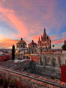 a view of a building with a sunset behind it at Suite de Lujo con Terraza Panorámica in San Miguel de Allende