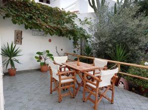 una mesa de madera y sillas en un patio en Veroniki Studios, en Kokkari