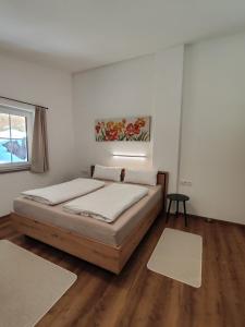 biała sypialnia z łóżkiem i oknem w obiekcie Apart Anna & Anton w mieście Brandberg