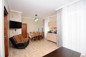 a living room with a couch and a table and a kitchen at Guest House Giorgi in Makhinjauri