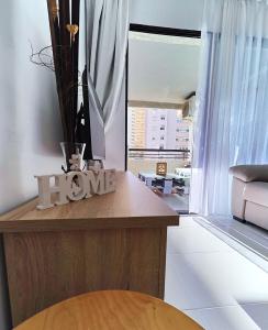 a living room with a table with a home sign on it at Piso Lux Mar in Benidorm