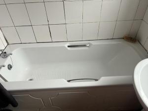 a white bath tub in a bathroom with a sink at Heywood in Heywood