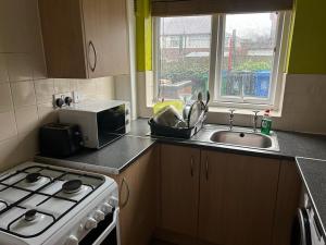 a kitchen with a stove and a sink and a microwave at Heywood in Heywood