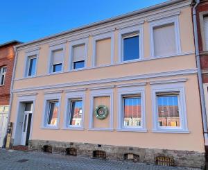 a pink building with white windows on a street at B&K Immobilien GbR in Tangermünde