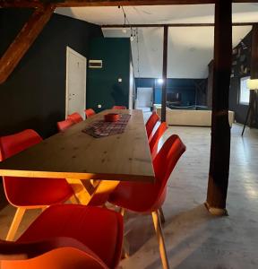 a dining room with a wooden table and red chairs at Blue Orange Hostel in Skopje