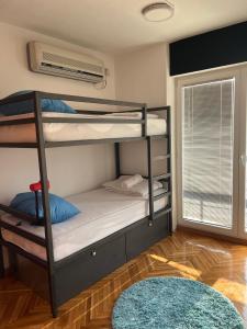 a bedroom with bunk beds with a window and a rug at Blue Orange Hostel in Skopje