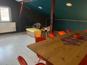 a dining room with a wooden table and orange chairs at Blue Orange Hostel in Skopje