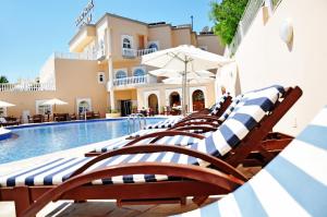 una fila de tumbonas junto a una piscina en Grand Hotel Palladium Santa Eulalia del Río, en Santa Eulària des Riu