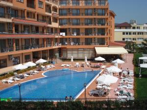 a swimming pool in front of a large building at Apart Hotel Happy in Sunny Beach