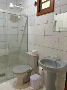a bathroom with a toilet and a sink at Pousada Canto do sabiá Imbassaí in Imbassai