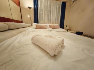 a large white bed with a towel on it at Stadion apartman in Belgrade