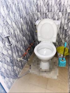 łazienka z białą toaletą z wężem w obiekcie Le Caire قاهرة w mieście Rufisque
