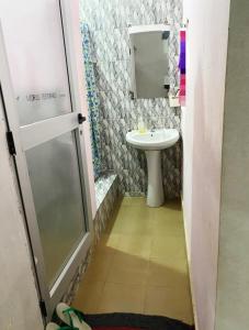 małą łazienkę z umywalką i lustrem. w obiekcie Le Caire قاهرة w mieście Rufisque