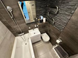 a bathroom with a sink and a toilet and a mirror at Tallinn's Prime Spot: Pae 49 - Near Airport, Concerts & Shops in Tallinn +34 photos