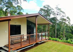 a screened in porch of a house with a large window at Bellthorpe Stays in Maleny