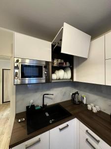 a kitchen with a sink and a microwave at Tallinn's Prime Spot: Pae 49 - Near Airport, Concerts & Shops in Tallinn
