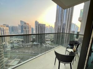 a balcony with two chairs and a view of a city at Superb New 2BR l High Floor l by Burj Khalifa & Dubai Mall I Pool I Gym in Dubai