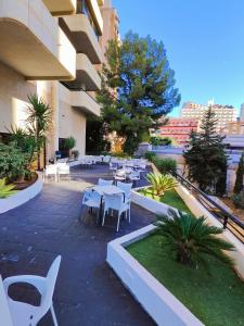 patio ze stołami i krzesłami w budynku w obiekcie Playa Levante Lux Mar w mieście Benidorm