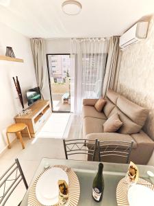 salon z kanapą i stołem w obiekcie Playa Levante Lux Mar w mieście Benidorm