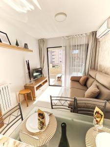 salon z kanapą i stołem w obiekcie Playa Levante Lux Mar w mieście Benidorm