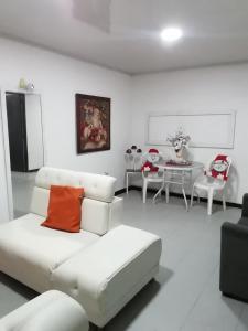 Sala de estar blanca con sofá y mesa en Apartamentos de Aura, en Cali