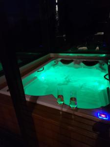 two wine glasses sitting next to a hot tub at Chalés Bergview in São Bento do Sapucaí