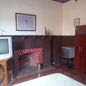 a living room with a fireplace and a television at Hostal María Luisa Bombal in Viña del Mar