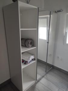 un armario con estantes blancos y espejo en Playgarza relax en Telde
