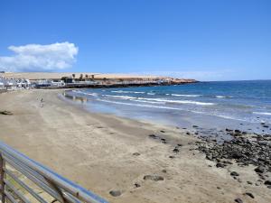 a view of a beach with people on a pier at Playgarza relax in Telde