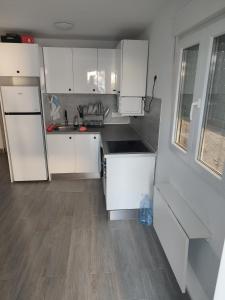 una cucina con armadietti bianchi e pavimenti in legno di Playgarza relax a Telde