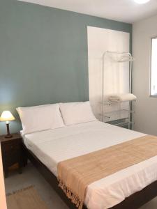a bedroom with a large bed with white sheets at Canto Santo in Itapoa