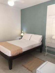 a bed with white sheets and pillows in a room at Canto Santo in Itapoa